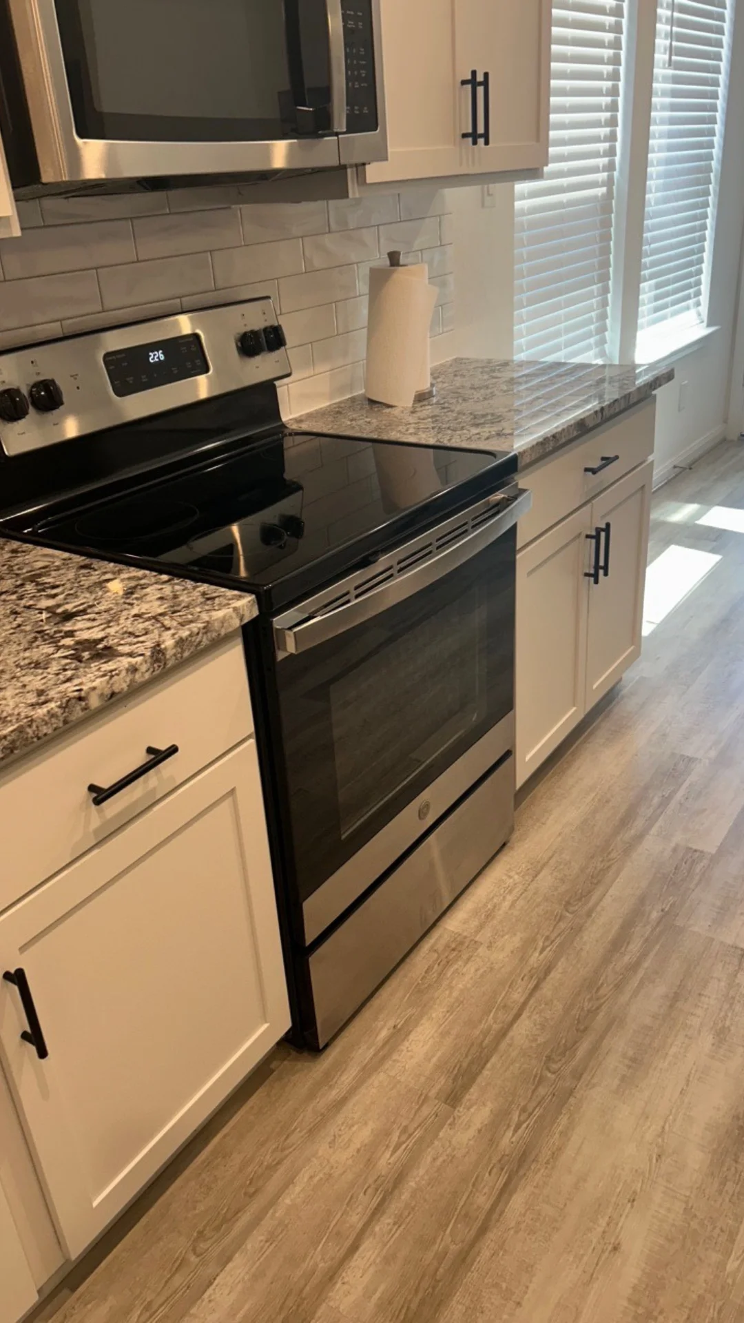 A clean glass stovetop and granite countertop in a spotless residential kitchen located in Round Rock, TX.