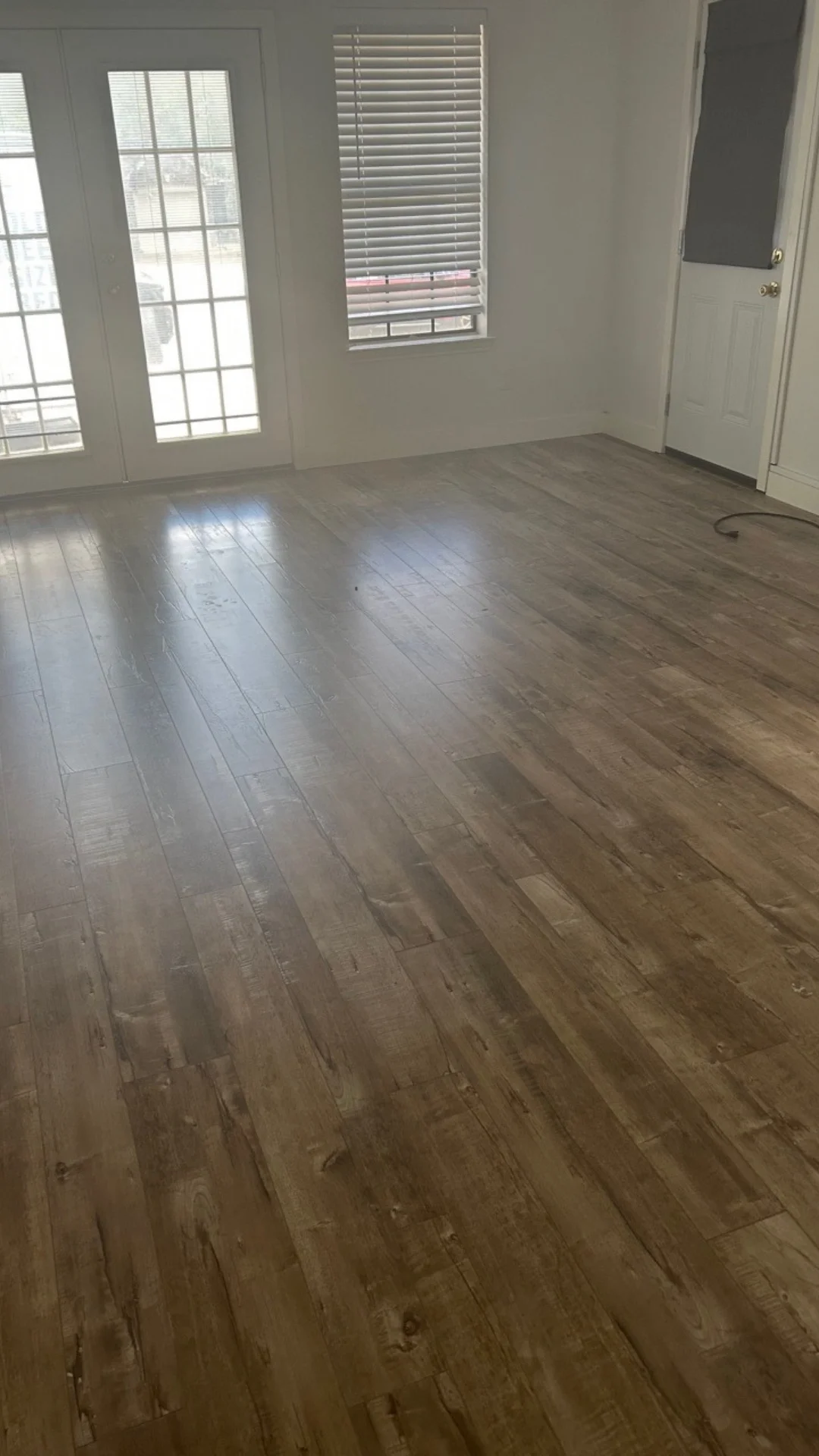 Sunlight shines on polished wooden floors in a clean, vacant living room in Killeen, TX.